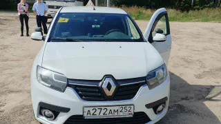 Белый учебный Renault Logan с открытыми дверями на площадке