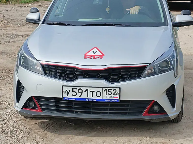 Серебристый учебный Kia Rio с табличкой «У»