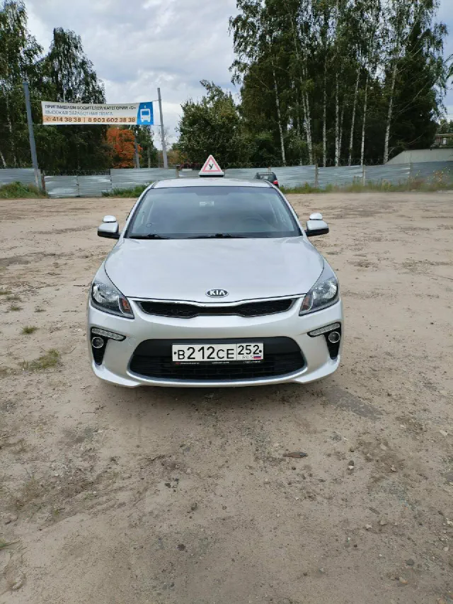 Серебристый учебный Kia Rio с табличкой «У», вид спереди