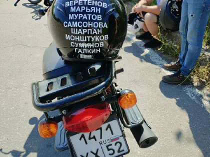 Учебный мотоцикл и шлем с надписями на баке