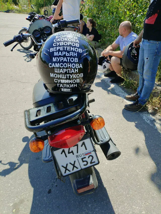Учебный мотоцикл и шлем с надписями на баке