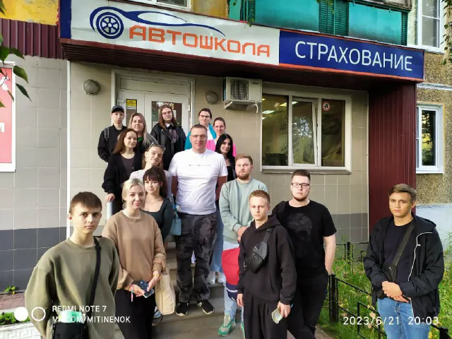 Группа у вывески автошколы